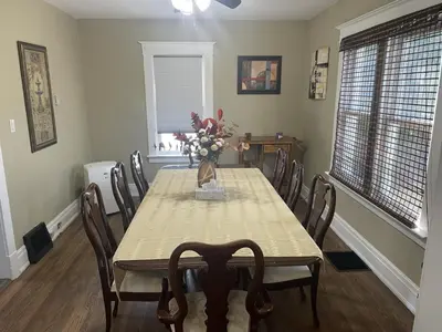 a dining room table with chairs and a vase of flowers at Exceptionally Close to the Falls Amazing Location & Complimentary Breakfast Delivered Daily to the Rental in Niagara Falls