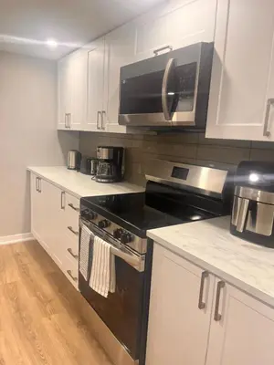 a kitchen with a black stove and a microwave at Bowmanville basement apartment in Bowmanville