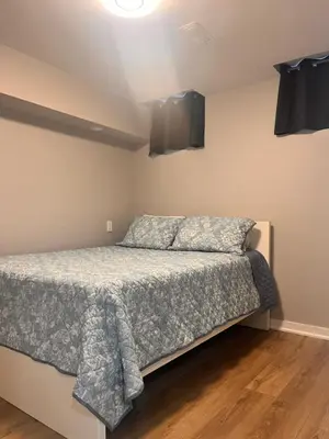 a bedroom with a bed and speakers on the wall at Bowmanville basement apartment in Bowmanville