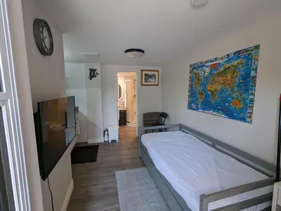 a bedroom with a bed and a clock on the wall at Modern Tiny Wood Cottage 0 in Wasaga Beach