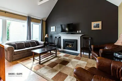 a living room with a couch and a fireplace at Mountain View Villas One Bed Loft Suite in Collingwood