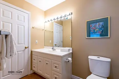 a bathroom with a sink and a toilet and a mirror at Mountain View Villas One Bed Loft Suite in Collingwood