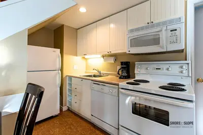 a kitchen with white appliances and a white microwave at Mountain View Villas One Bed Loft Suite in Collingwood