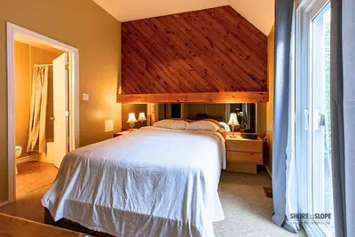 a bedroom with a large bed with a wooden ceiling at Mountain View Villas One Bedroom Suite in Collingwood