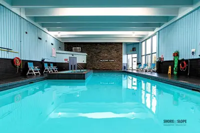 a swimming pool with blue water in a building at Mountain View Villas One Bedroom Suite in Collingwood