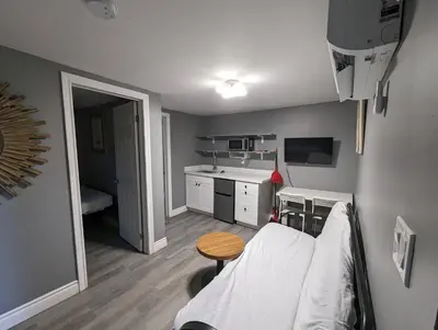a small room with a bed and a kitchen at Modern Tiny Wood Cottage 03 in Wasaga Beach