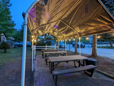 a group of picnic tables under a tent at Modern Tiny Wood Cottage 03 in Wasaga Beach