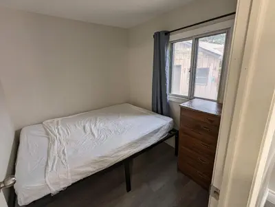 a small bedroom with a bed and a window at Modern Tiny Wood Cottage 04 in Wasaga Beach