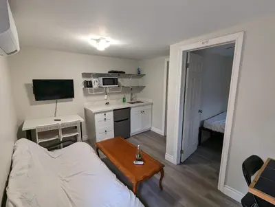 a living room with a white couch and a table at Modern Tiny Wood Cottage 04 in Wasaga Beach