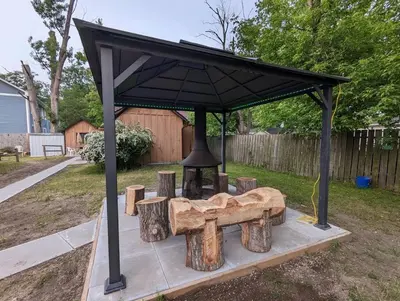 a picnic shelter with a bell in a yard at Tiny Wood Cottage 05 in Wasaga Beach