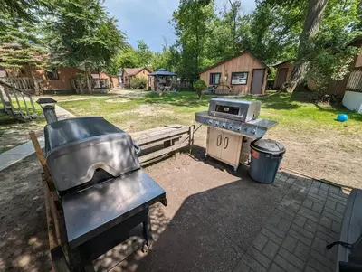 a grill and a stove in a backyard at Tiny Wood Cottage 05 in Wasaga Beach