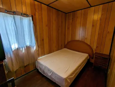 a small bedroom with a bed and a window at Tiny Wood Cottage 06 in Wasaga Beach