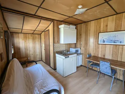 a small kitchen in a trailer with a table and chairs at Tiny Wood Cottage 06 in Wasaga Beach