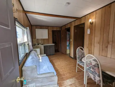 a room with a couch and a table and a kitchen at Tiny Wood Cottage 07 in Wasaga Beach