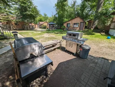 a grill and a stove in a backyard at Tiny Wood Cottage 08 in Wasaga Beach