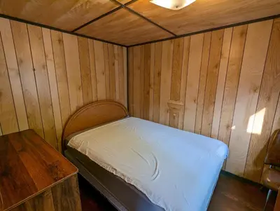 a small room with a bed and a table at Tiny Wood Cottage 09 in Wasaga Beach