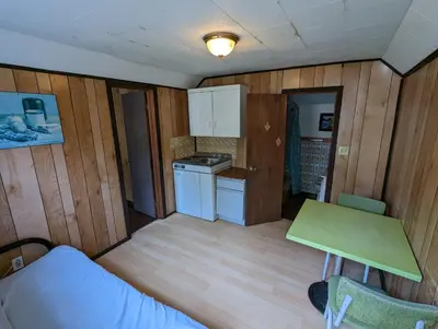 a small room with a kitchen and a table at Tiny Wood Cottage 11 in Wasaga Beach