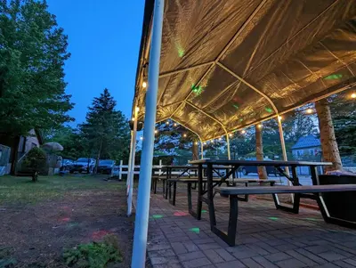 a group of picnic tables under a tent at Tiny Wood Cottage 11 in Wasaga Beach