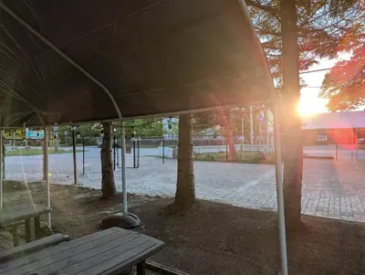 a picnic table in a park with the sun setting at Tiny Wood Cottage 12 in Wasaga Beach