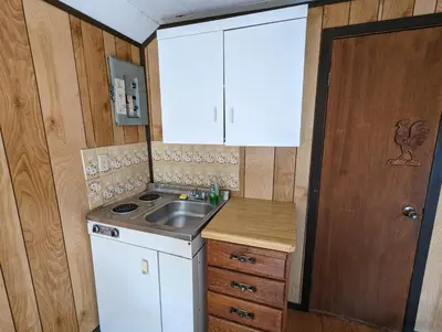 a small kitchen with a sink and a stove at Tiny Wood Cottage 12 in Wasaga Beach