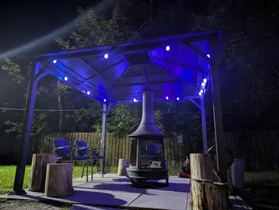 a blue gazebo with a fireplace under it at night at Tiny Wood Cottage 12 in Wasaga Beach