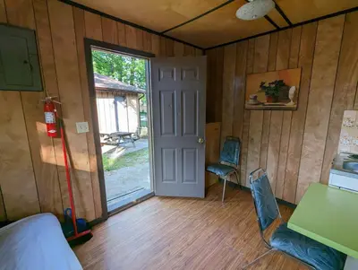 a room with a door and a table and chairs at Tiny Wood Cottage 19 in Wasaga Beach