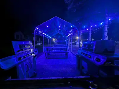 a picnic table in the dark with blue lights at Tiny Wood Cottage 20 in Wasaga Beach