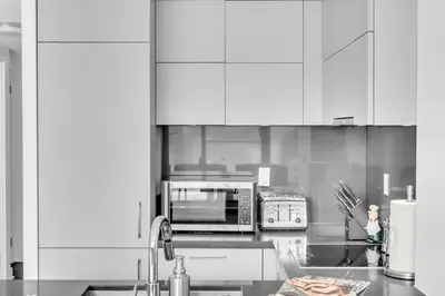 a kitchen with white cabinets and a microwave oven at The Royal 2 Bedroom Condo Yorkville in Toronto