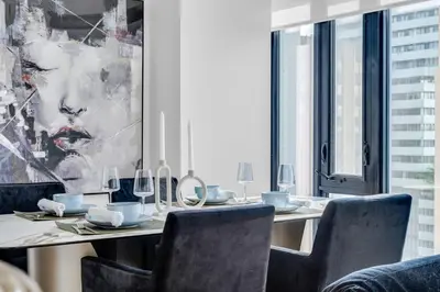 a dining room with a table with chairs and a painting at The Royal 2 Bedroom Condo Yorkville in Toronto