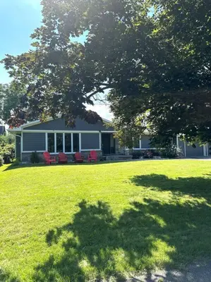 a house on a lawn with a tree in the foreground at Alba Cottage with Brand New Pool in Queenston