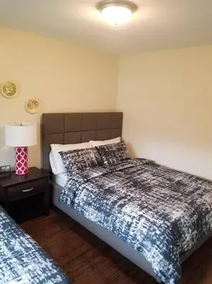 a bedroom with two beds and a lamp on a table at Alba Cottage with Brand New Pool in Queenston
