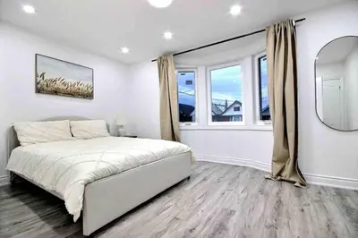 a bedroom with a bed and a large window at Modern Luxury Home next to Tim Hortons Field in Hamilton