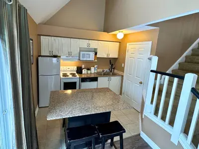 a kitchen with white cabinets and a counter top at Mountain Loft Suite with Pool and Hot Tub in Blue Mountains