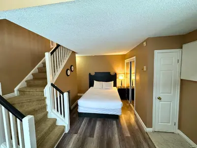 a bedroom with a bed and a staircase at Mountain Loft Suite with Pool and Hot Tub in Blue Mountains