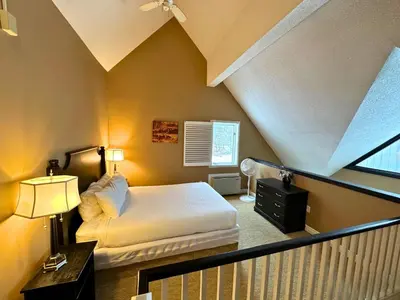 a small bedroom with a bed and a window at Mountain Loft Suite with Pool and Hot Tub in Blue Mountains