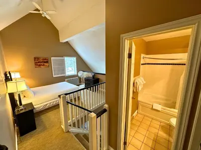 a small room with a bed and a bathroom at Mountain Loft Suite with Pool and Hot Tub in Blue Mountains