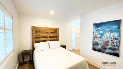 a bedroom with a bed and a painting on the wall at The 1883 Century Flat Suite in Collingwood