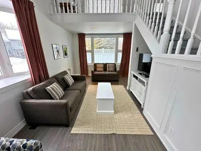 a living room with a couch and a tv at Four Season Family Retreat with Pool Access in Collingwood