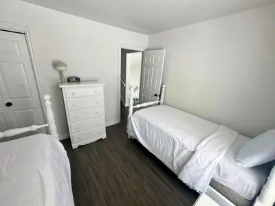 a bedroom with two beds and a dresser and a mirror at Four Season Family Retreat with Pool Access in Collingwood