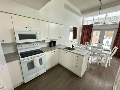 a kitchen with white cabinets and a stove top oven at Four Season Family Retreat with Pool Access in Collingwood