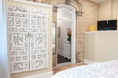 a white door in a bedroom with a bed at Stone Maiden Inn in Stratford