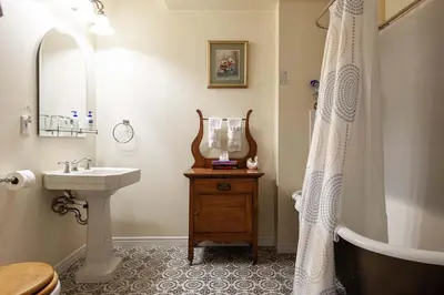 a bathroom with a sink and a tub and a shower curtain at Stone Maiden Inn in Stratford