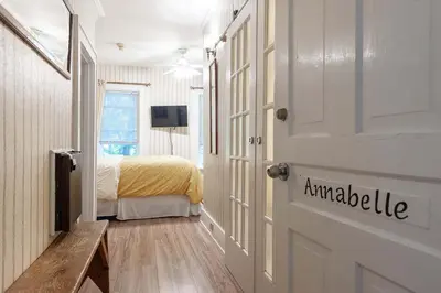 a room with a door with a bed and a television at Stone Maiden Inn in Stratford