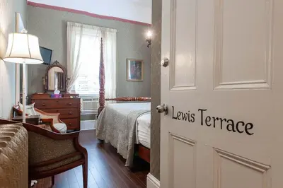 a bedroom with a bed and a door with the words louisiane variance at Stone Maiden Inn in Stratford