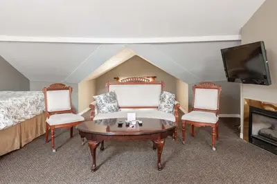 a bedroom with a bed and a table and two chairs at Stone Maiden Inn in Stratford