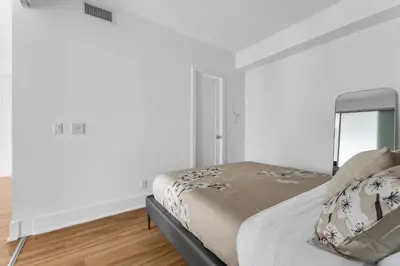 a bedroom with a bed and a window and white walls at Estate 1 Bedroom Condo Front Street West in Toronto
