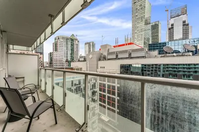 a balcony with chairs and a view of a city at Estate 1 Bedroom Condo Front Street West in Toronto