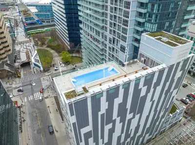 an overhead view of a building with a swimming pool on top at Estate 1 Bedroom Condo Front Street West in Toronto