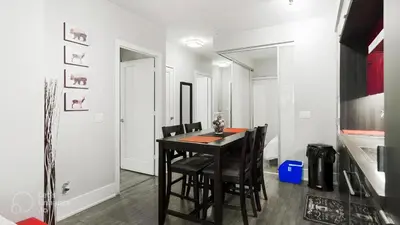 a dining room with a black table and chairs at Skyline Suites - Walk to MTCC, ACC, Rogers Centre & Entertainment District in Toronto