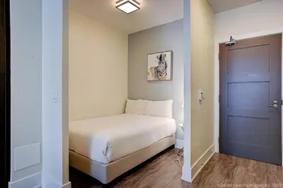 a small bedroom with a bed and a blue door at Skyline Suites - Walk to MTCC, ACC, Rogers Centre & Entertainment District in Toronto